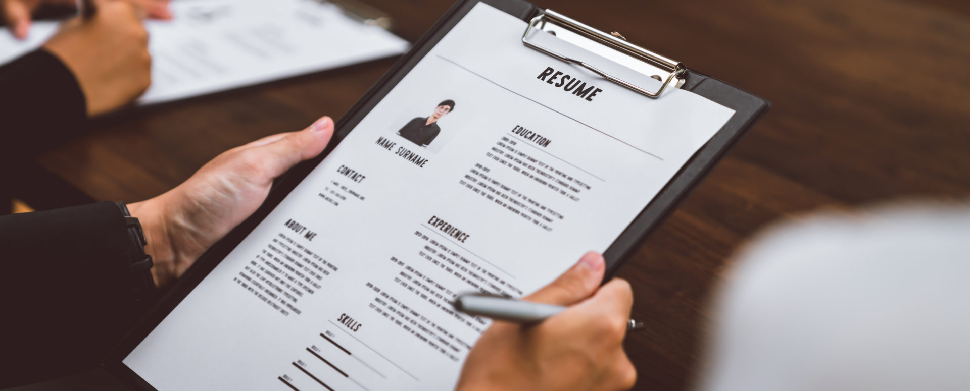 Hiring manager reviews job applicant's resume at her desk