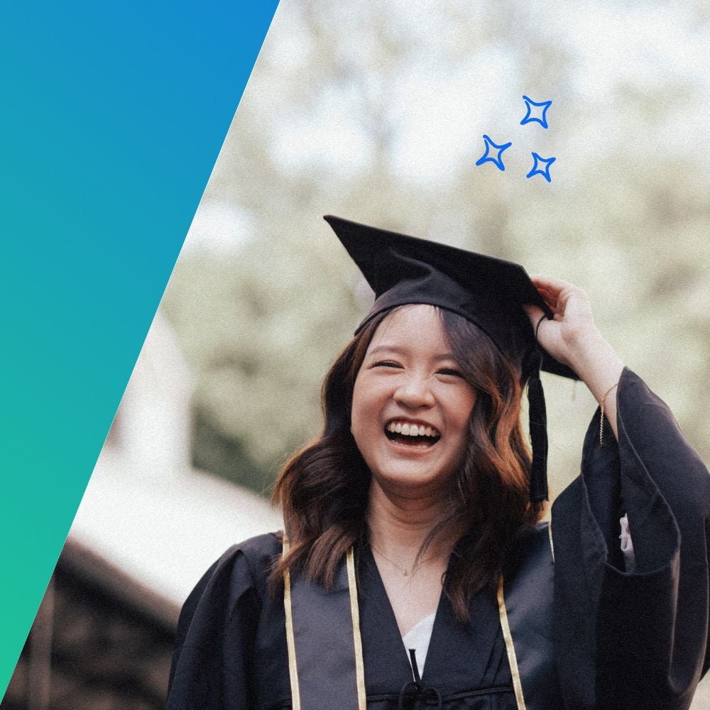 A young woman in a graduation cap and gown, smiling brightly as she holds her cap.