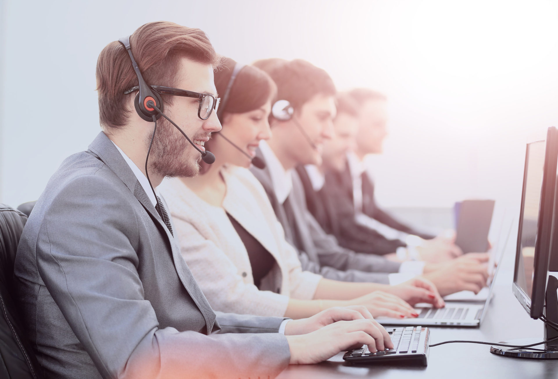 Professionals talking on their headsets and typing on their computers