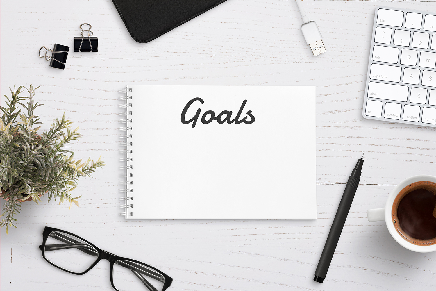 White notebook with the word "Goals" written on the front