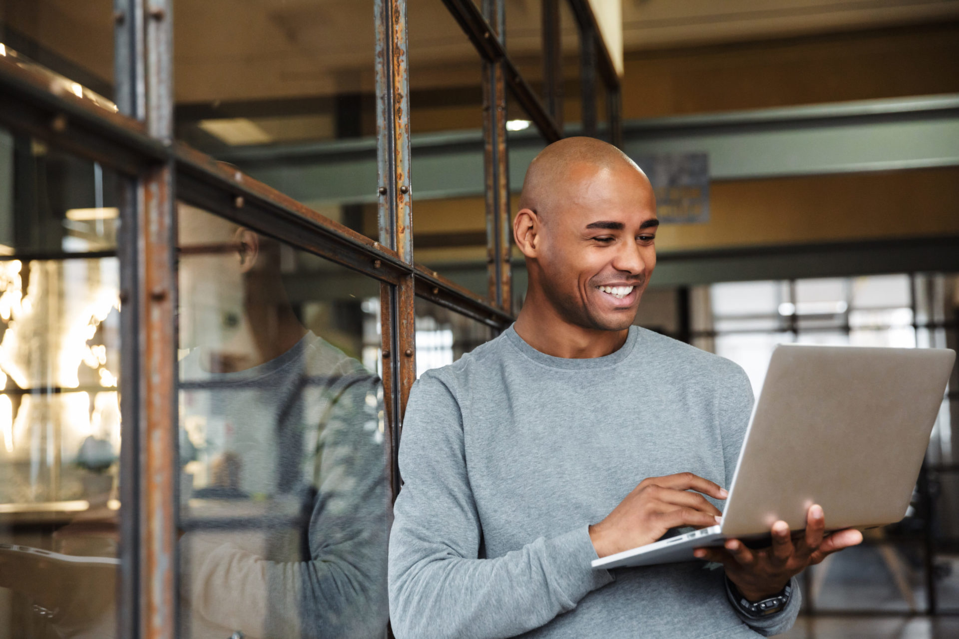 Male professional holding his laptop while working in office