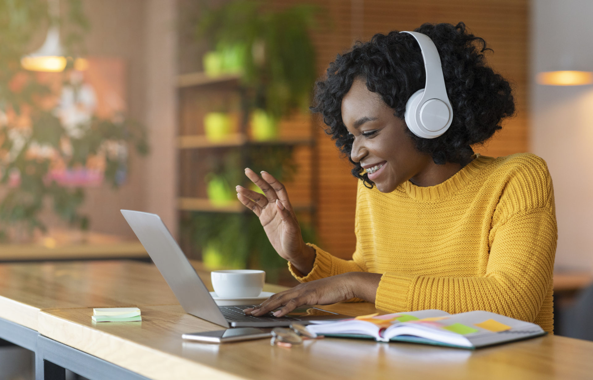 Female professional wearing headphones and on a video call through her laptop