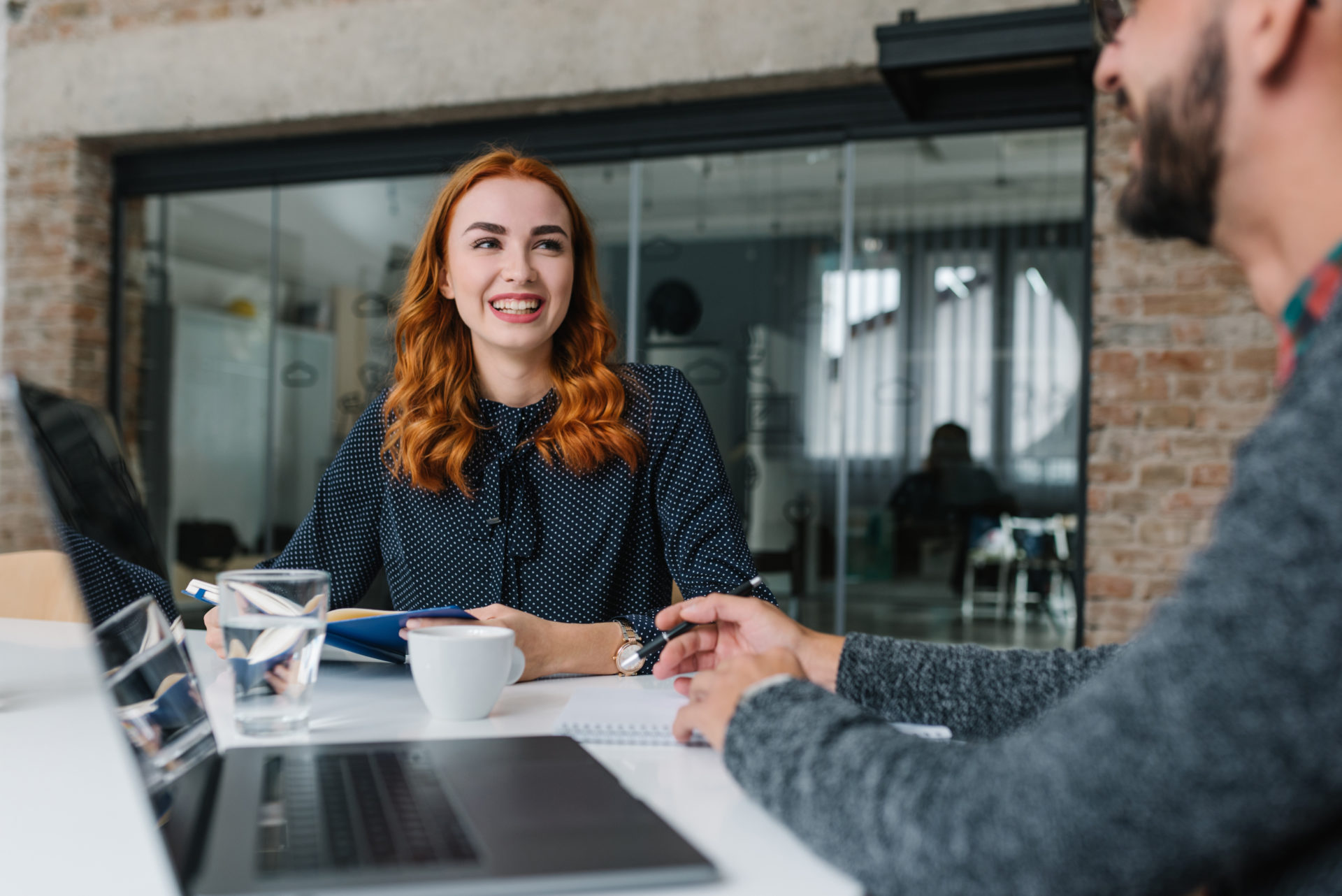 Female professional sitting at a desk across from her male interviewer