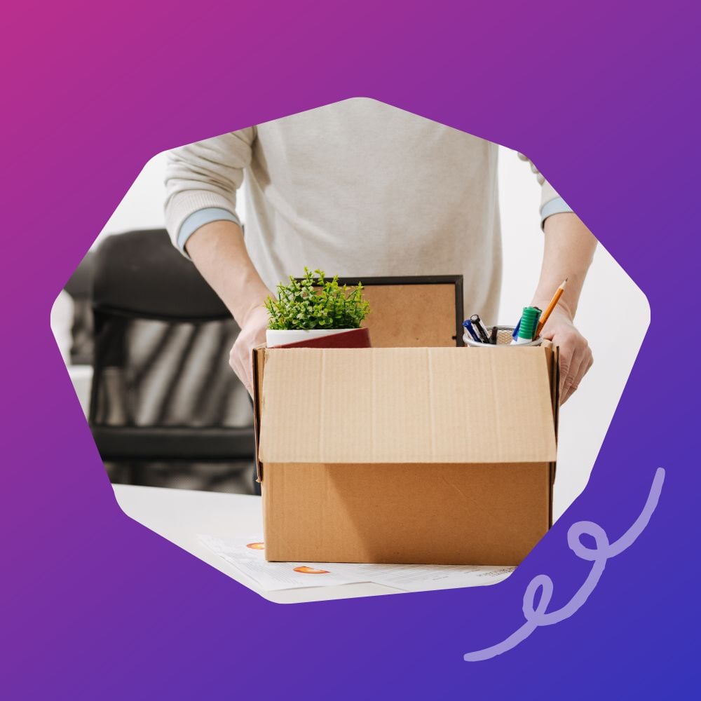 Man putting his desk supplies into a box after quitting his job