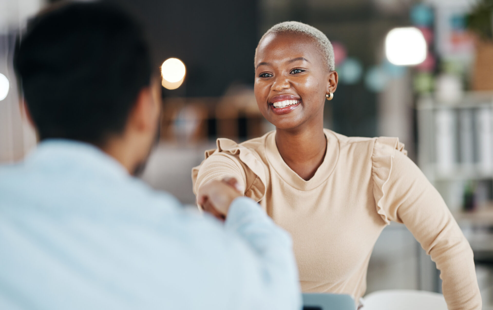 Woman HR candidate shaking male hiring manager's hand at the start of the interview