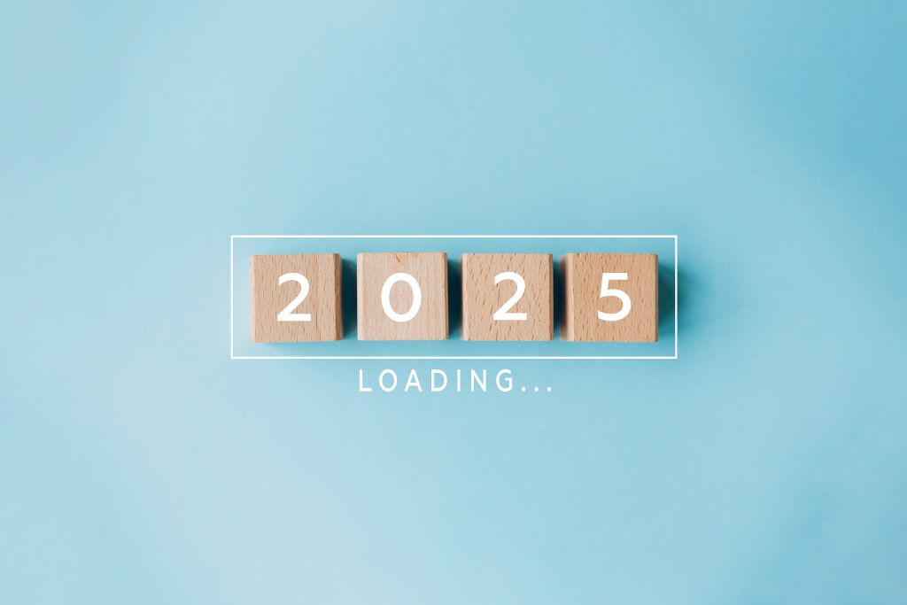 Wooden blocks spelling '2025' with the text 'LOADING...' underneath, set against a light blue background.