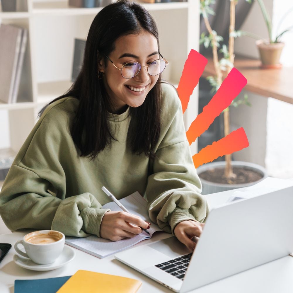 Girl high school student at home researching information about college on her laptop and taking notes with a pencil in a notebook