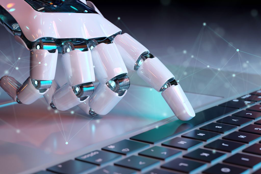 Close-up of a robotic hand typing on a laptop keyboard, symbolizing the integration of artificial intelligence and technology in modern workplaces.